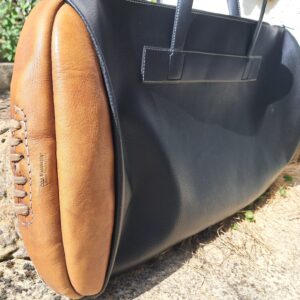 A sports bag decorated with a leather ball from 'John Woodbridge Makers'