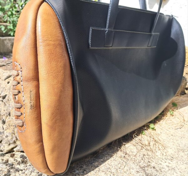 A sports bag decorated with a leather ball from 'John Woodbridge Makers'